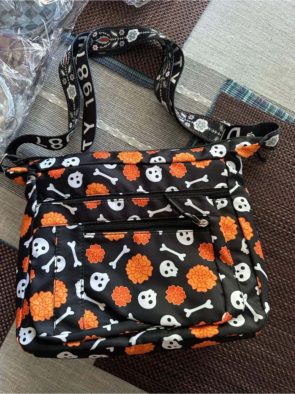 Halloween-themed crossbody bag featuring a skull and marigold print